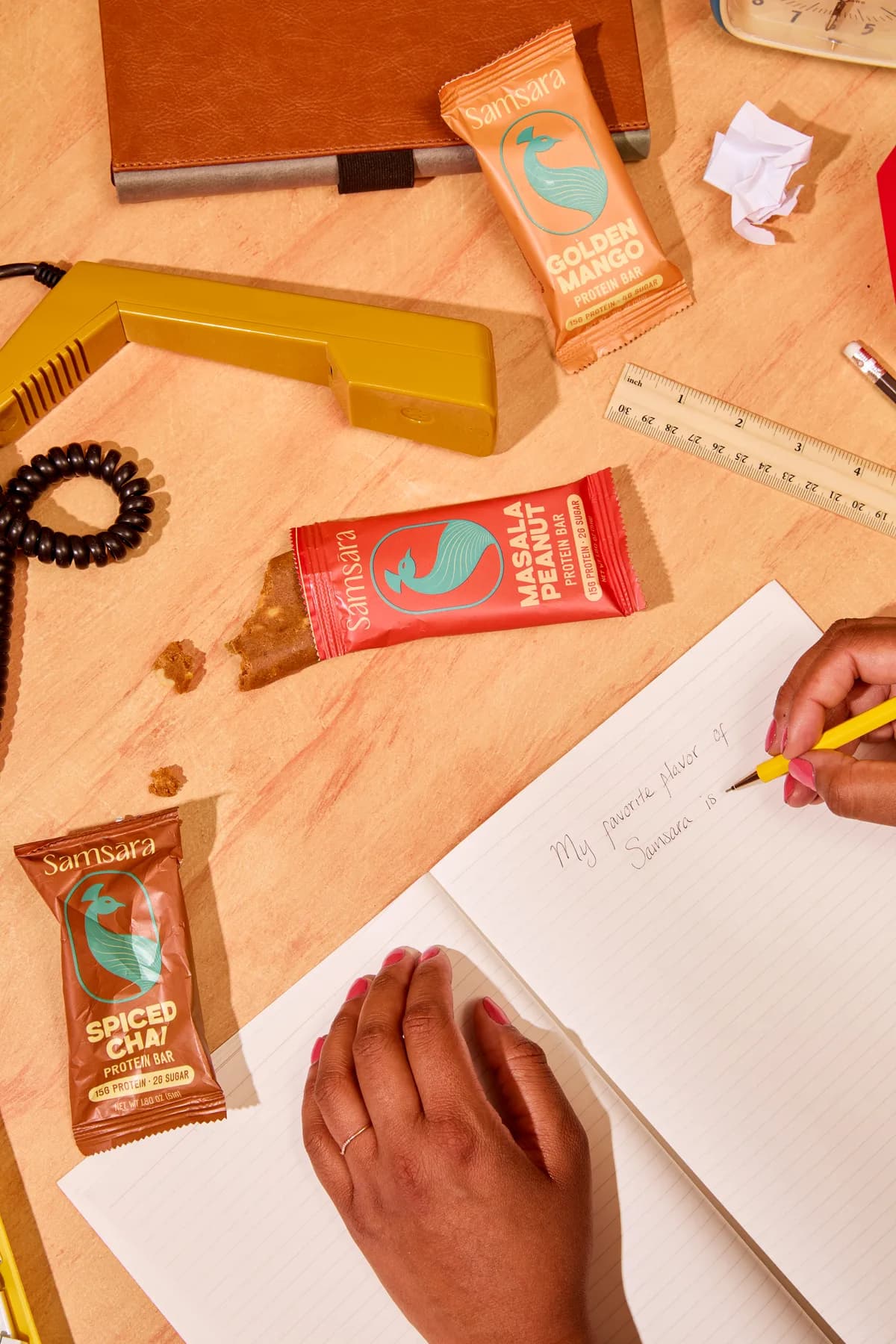 All three Samsara bars on an office desk with a notebook and yellow rotary phone
