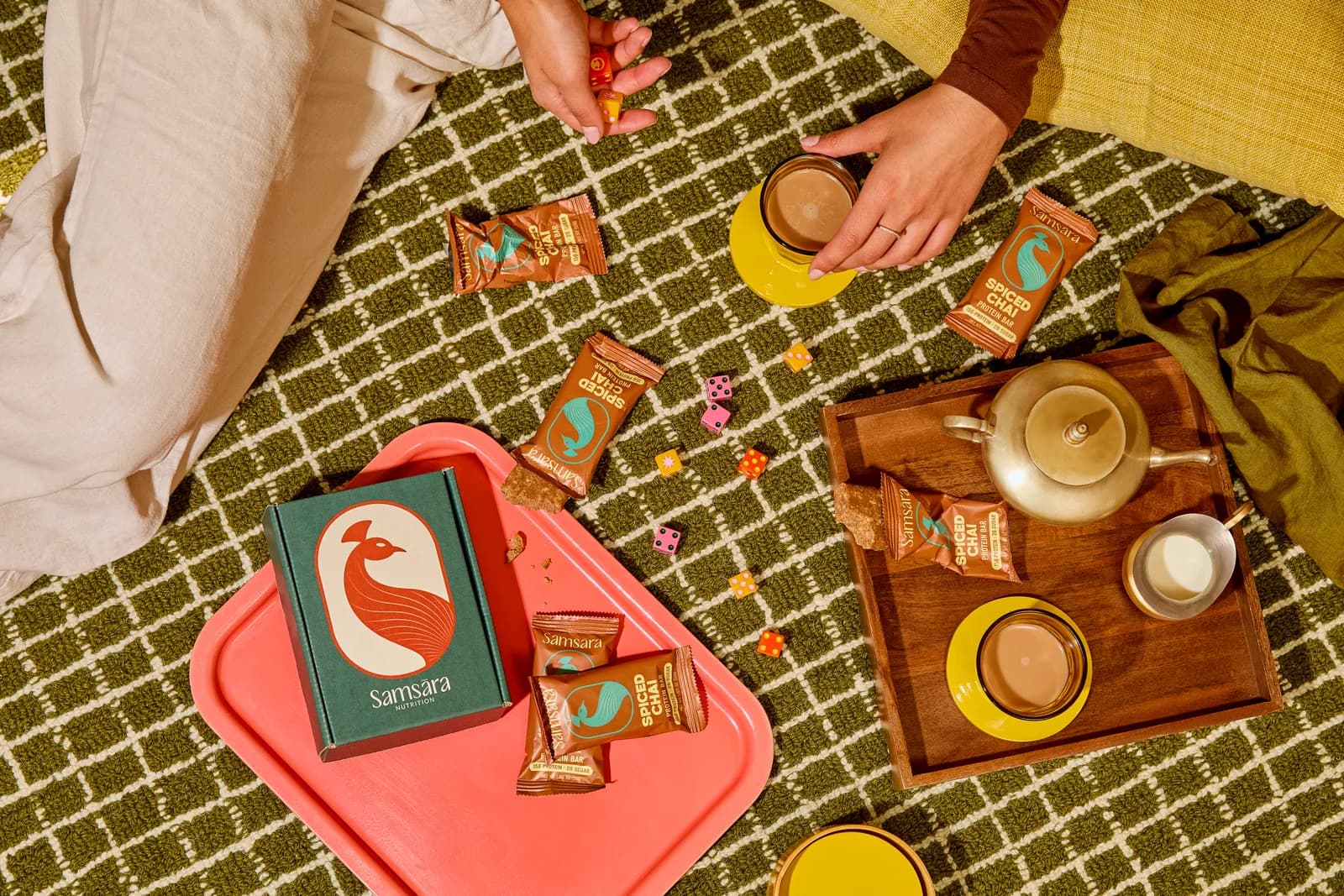 Spiced Chai bars on a green woven blanket with a brass teapot and tea cups